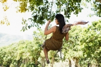 Back view of young woman on swing