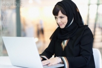 Arab woman using laptop in office
