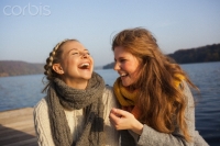 Two young women sharing leisure time at lake